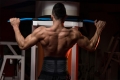 Muscular Young Man Exercising In Gym